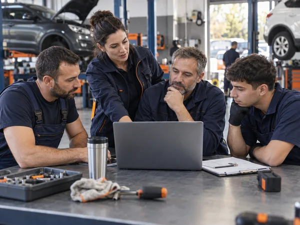 Equipo de taller planificando el trabajo junto a un ordenador
